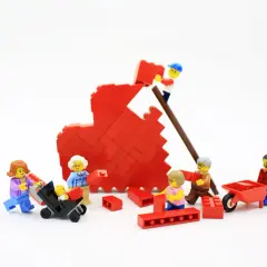 Figuras de Lego construyen un corazón rojo, simbolizando la bisquerra educación emocional y el trabajo en equipo familiar.