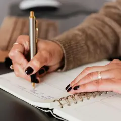 Mano escribiendo en un cuaderno, un paso más para aprender a escribir.