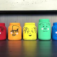 Manualidades de frascos pintados con caras que expresan diferentes emociones: sorpresa, enfado, alegría, amor, tristeza y más.