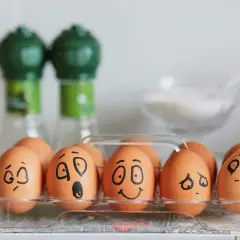 Huevos en una caja con caras dibujadas, mostrando una divertida actividad de las emociones.