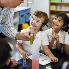 Niños con gafas de seguridad observan un experimento, aprendiendo qué es un STEM.