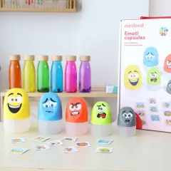 Juguetes para la inteligencia emocional infantil: cápsulas con caras de emociones y tarjetas.