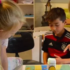 Niños concentrados en deberes de verano originales, programando un robot.