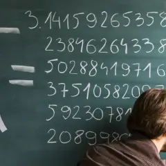 Un hombre escribe el número pi en una pizarra, mostrando sus infinitos dígitos.