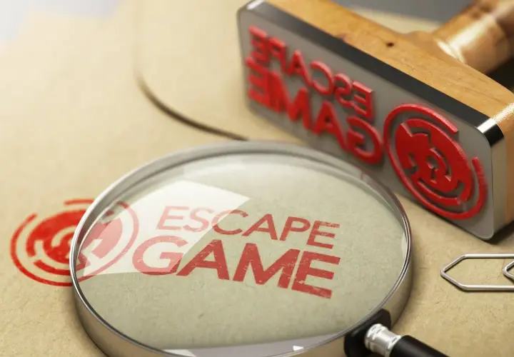 Lupa y sello de "Escape Game" sobre papel, buscando los mejores escape room online.