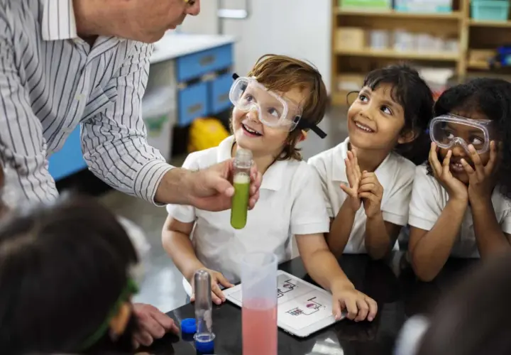 Niños con gafas de seguridad observan un experimento, aprendiendo qué es un STEM.