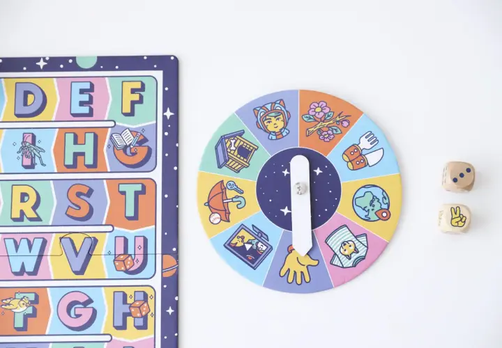 Juego de mesa para lectoescritura infantil con abecedario y ruleta de imágenes. Dados de madera con números y símbolos.
