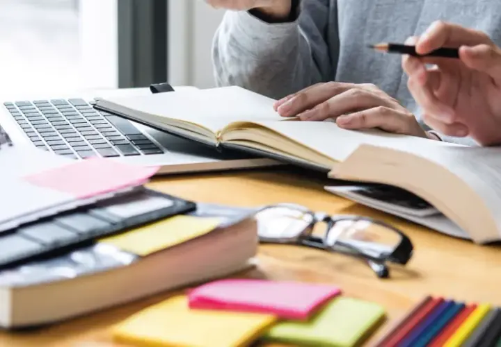 Estudiantes revisando apuntes y libros, preparándose para exámenes. Una guía visual sobre como volver a estudiar y organizar el material.