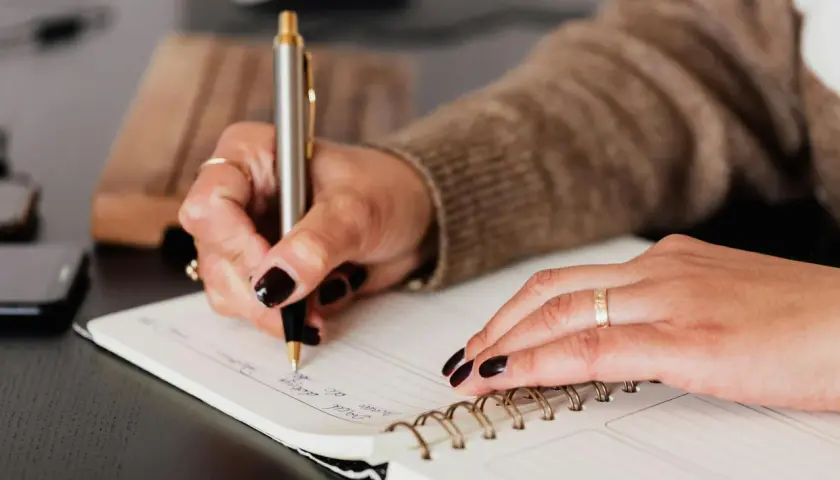 Mano escribiendo en un cuaderno, un paso más para aprender a escribir.