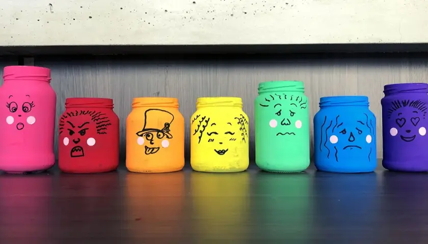 Manualidades de frascos pintados con caras que expresan diferentes emociones: sorpresa, enfado, alegría, amor, tristeza y más.