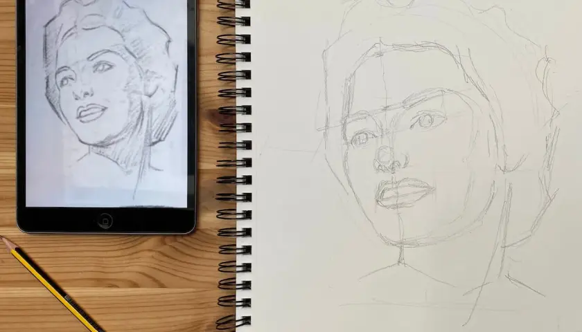 Aprendiendo como dibujar retratos. Boceto a lápiz de un rostro en un cuaderno, con una tablet mostrando el modelo.