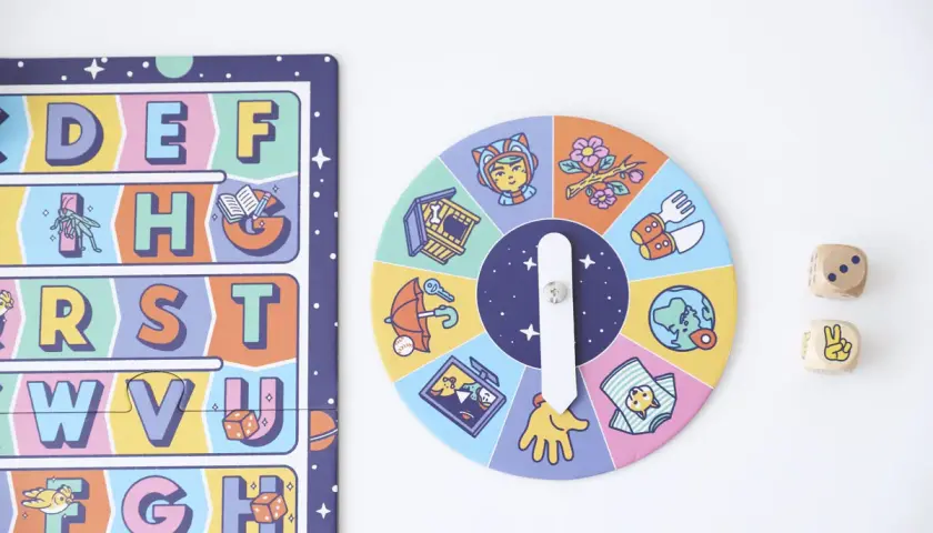 Juego de mesa para lectoescritura infantil con abecedario y ruleta de imágenes. Dados de madera con números y símbolos.