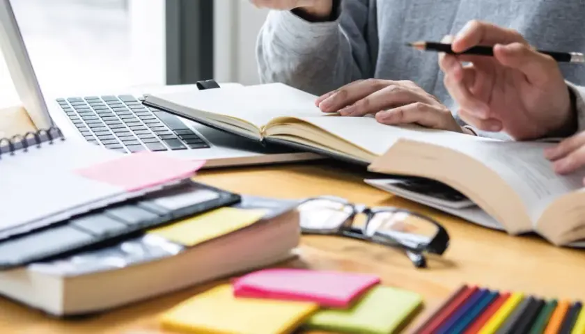 Estudiantes revisando apuntes y libros, preparándose para exámenes. Una guía visual sobre como volver a estudiar y organizar el material.