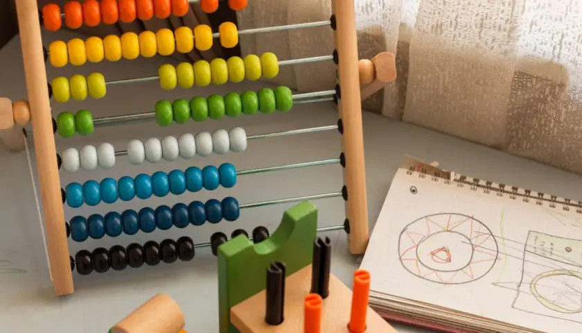 Ábaco de colores y cuaderno con dibujos, herramientas para aprender como trabajar la concentración en niños.