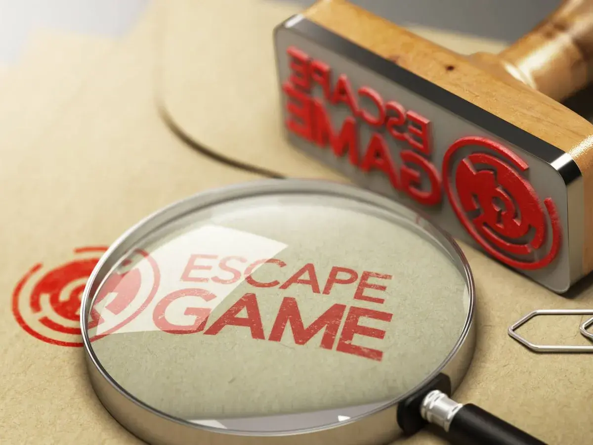 Lupa y sello de "Escape Game" sobre papel, buscando los mejores escape room online.