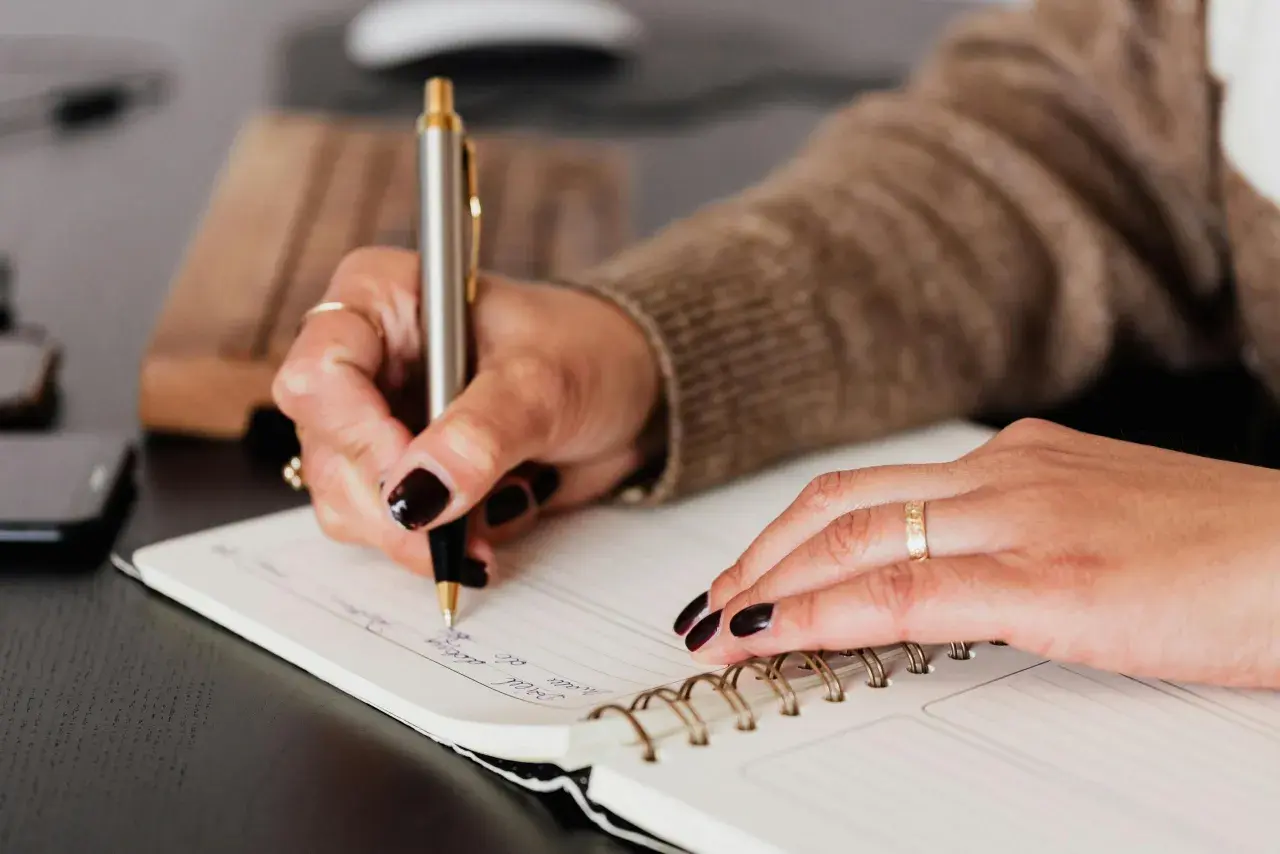 Mano escribiendo en un cuaderno, un paso más para aprender a escribir.
