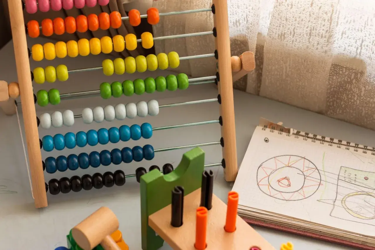 Ábaco de colores y cuaderno con dibujos, herramientas para aprender como trabajar la concentración en niños.