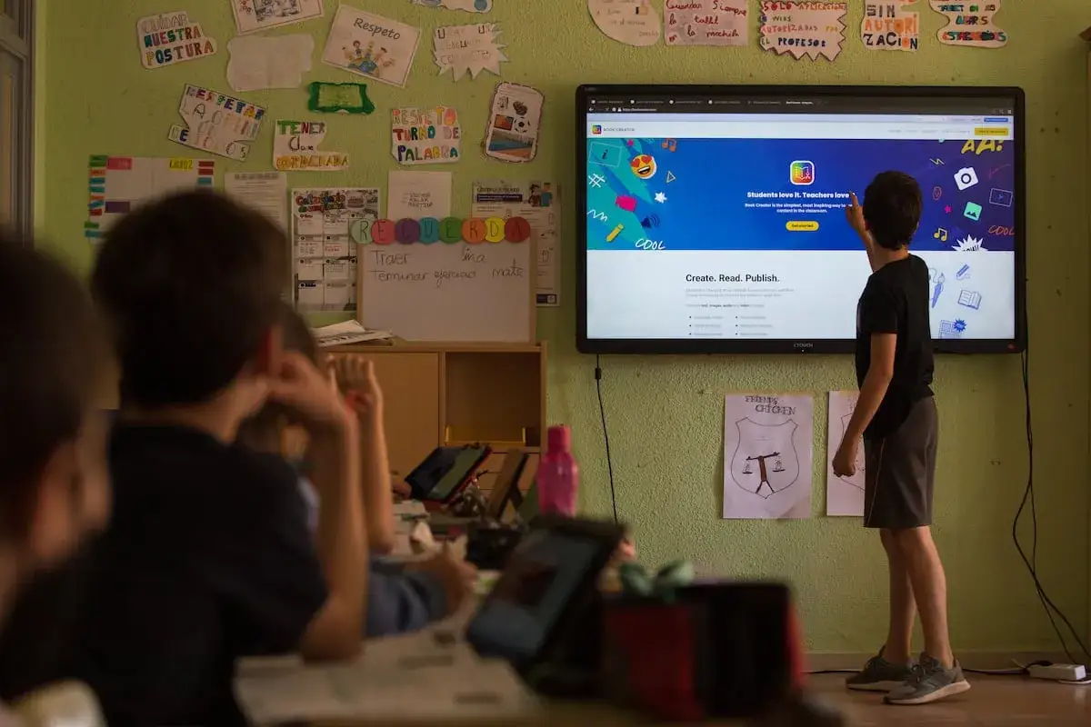 Un niño interactúa con una pantalla que muestra recursos para crear videos educativos de primaria.