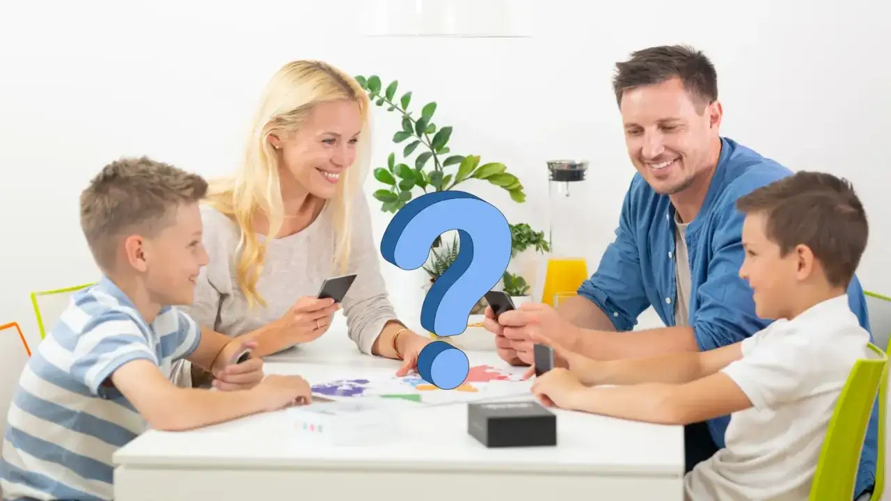 Familia jugando un acertijo para ni&ntilde;os. Un signo de interrogaci&oacute;n azul flota sobre la mesa, donde padres e hijos interact&uacute;an con sus tel&eacute;fonos y un juego de mesa.