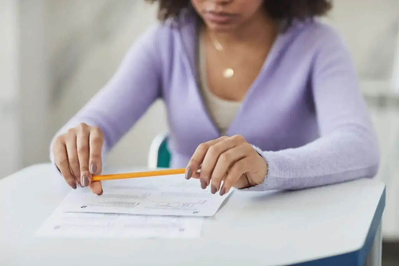 Estudiante concentrada, lápiz en mano, preparándose para como estudiar para un examen de desarrollo.