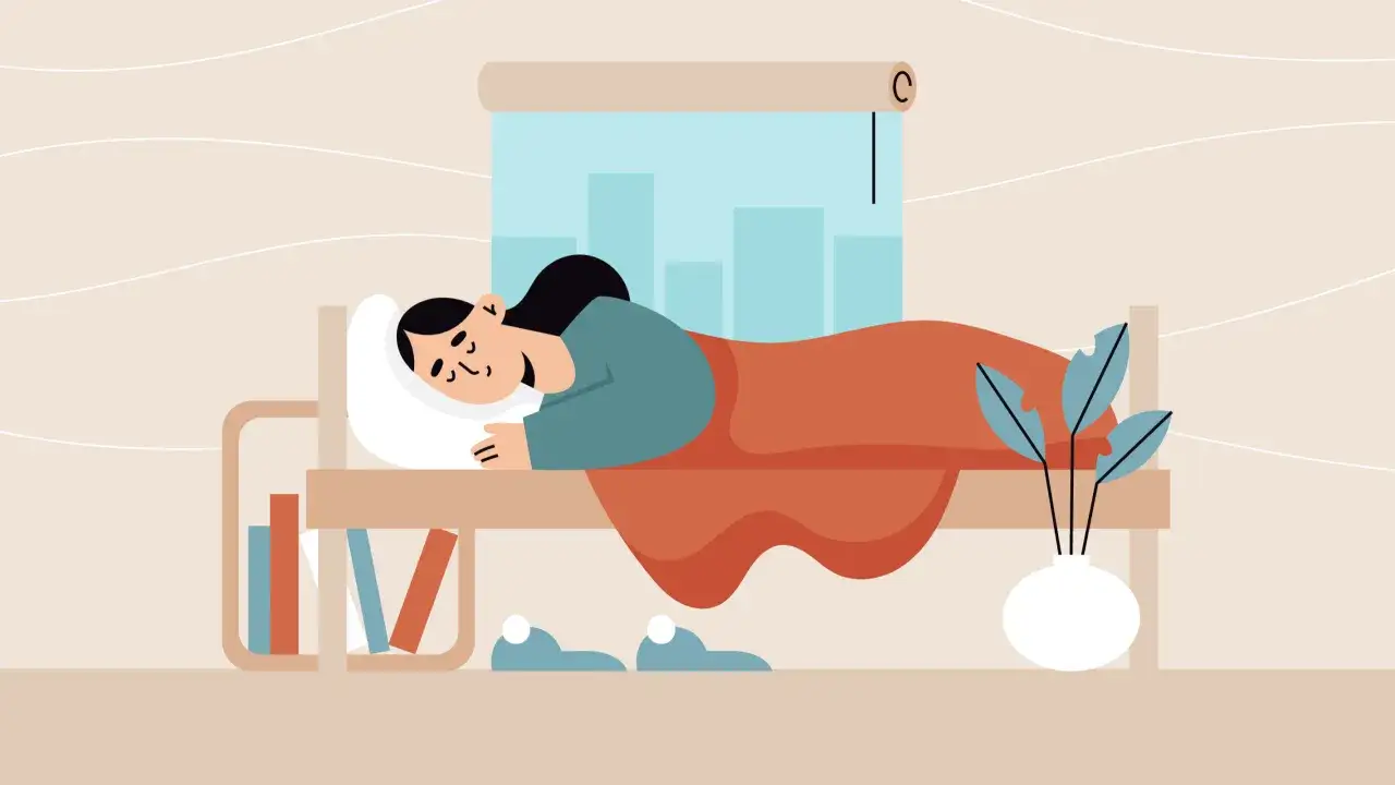 Una persona duerme plácidamente, envuelta en una manta naranja. La escena ilustra la importancia del descanso para recargar energías.
